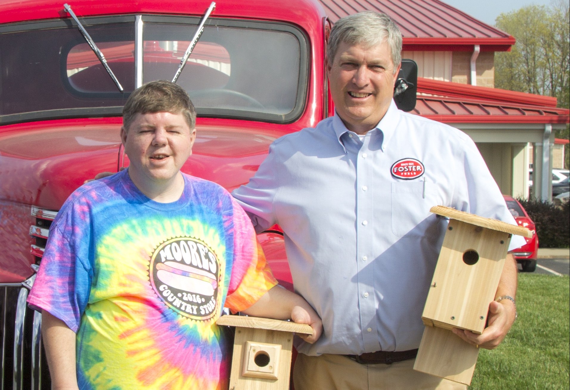 Chris Russell and Watt Foster Stand together holding handcrafted birdhouses